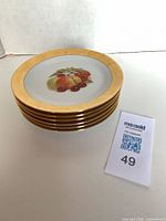 Stacked porcelain plates side profile showing gold rims and quantity