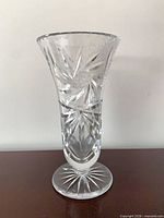 Front view of clear cut crystal trumpet vase on foot