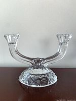 Front view of clear cut glass two-arm candelabra showing starburst base