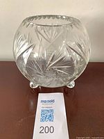Front view of spherical cut crystal rose bowl on three feet
