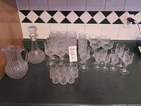 Full set displayed on countertop: pitcher, decanter, assorted stemware and shot glasses