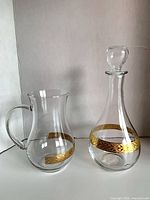 Both decanter with stopper and pitcher showing gold bands