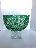 Front angled view showing green cut-to-clear bowl on clear square pedestal foot