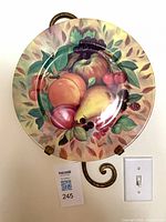 Front of porcelain plate on hanger displaying fruit motif