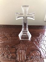Front view of clear glass cross on pedestal