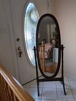 Front view of oval cheval mirror showing frame and stand