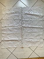Square white cutwork linen tablecloth laid flat