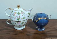 Front view of floral tea-for-one set beside cobalt blue sugar bowl music box