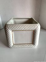 Front view of square ribbed ceramic planter with gold-trimmed panel