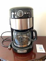 Front view of KitchenAid drip coffee maker with carafe and power cord