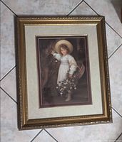 Front view showing framed child portrait print with ornate gold frame