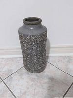 Full view of gray textured ceramic vase standing upright