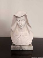 Front view of white marble Madonna bust on gray marble base