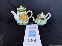 Front view of both miniature teapots side by side