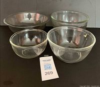 Front view of four clear glass mixing bowls