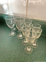 Front view of ten clear stemmed glasses in two sizes