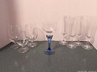All eight glasses grouped: four wine goblets, one cordial, three champagne flutes