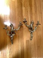 Both brass Rococo two-arm sconces front view