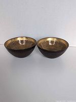 Pair of brown exterior, gold interior diamond-pattern glass bowls side by side