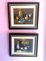Both framed paintings hung on wall