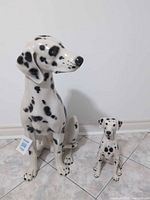 Large and small ceramic Dalmatian figurines front view