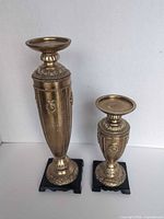 Front view of both candlesticks showing size difference and design