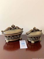 Front view of both ornate oval trinket boxes showing Baroque detailing and size difference