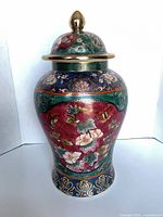 Front view of porcelain ginger jar with lid showing floral design and gold finial