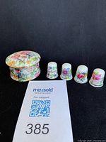 Lot overview showing trinket box and four thimbles