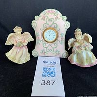 Front view of mantel clock and two angel figurines