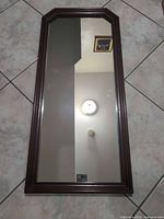 Front view of rectangular brown wood wall mirror