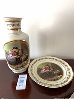 Vase and plate showing Murillo scene and gold trim