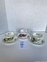 Three teacup and saucer sets displayed