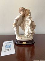 front view of porcelain bride and groom figurine on wood base