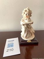 Front view of figurine on wood base with lot card