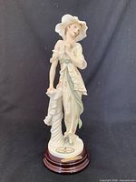 Front view of porcelain figurine on wooden base with identifying plaque