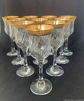 Front view of all ten ribbed wine glasses showing gold rim detail