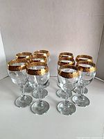 All ten gold-rimmed wine glasses