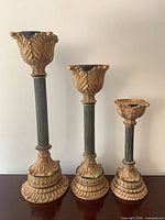 Front view showing three graduated gold and green neoclassical candle holders