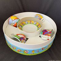Set in presentation box showing four cups and central saucers