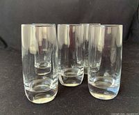 Front angled view of five clear glass shot glasses