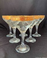 Front angled view showing all six coupe glasses and gold rims