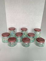 Front view all nine floral glass jars with pink lids