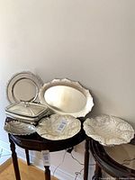 All six silver-plated pieces arranged on tables