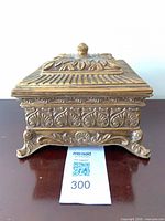 Front view of ornate gilded resin jewelry box