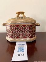 Front view of red and gold porcelain trinket box with lid on