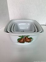 Four stacked ceramic bowls showing exterior pear motif