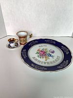 Front view of cobalt blue 25th Anniversary plate, two demitasse cups and saucer