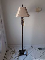 Full view of bronze floor lamp with shade and cord