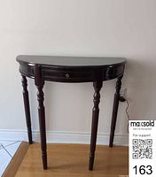 Full view of demilune console table against wall